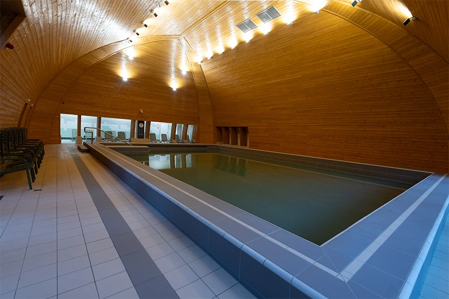 Dark indoor swimming pool with unbalanced lighting and weak composition
