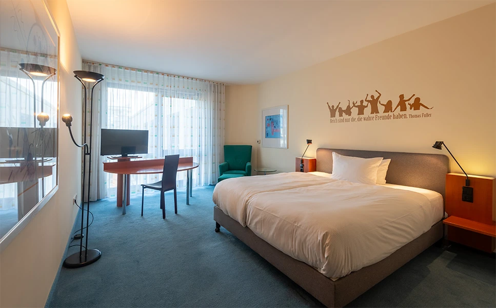 Sloppy hotel bed with wrinkled sheets and unkempt presentation
