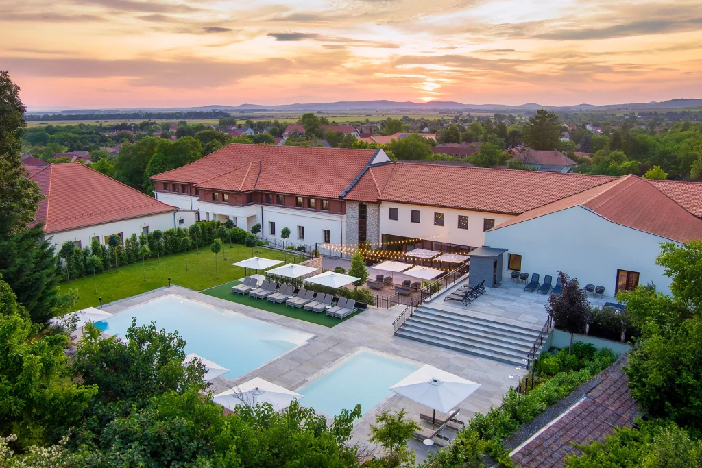 Scenic hotel exterior with outdoor pool and sunset view
