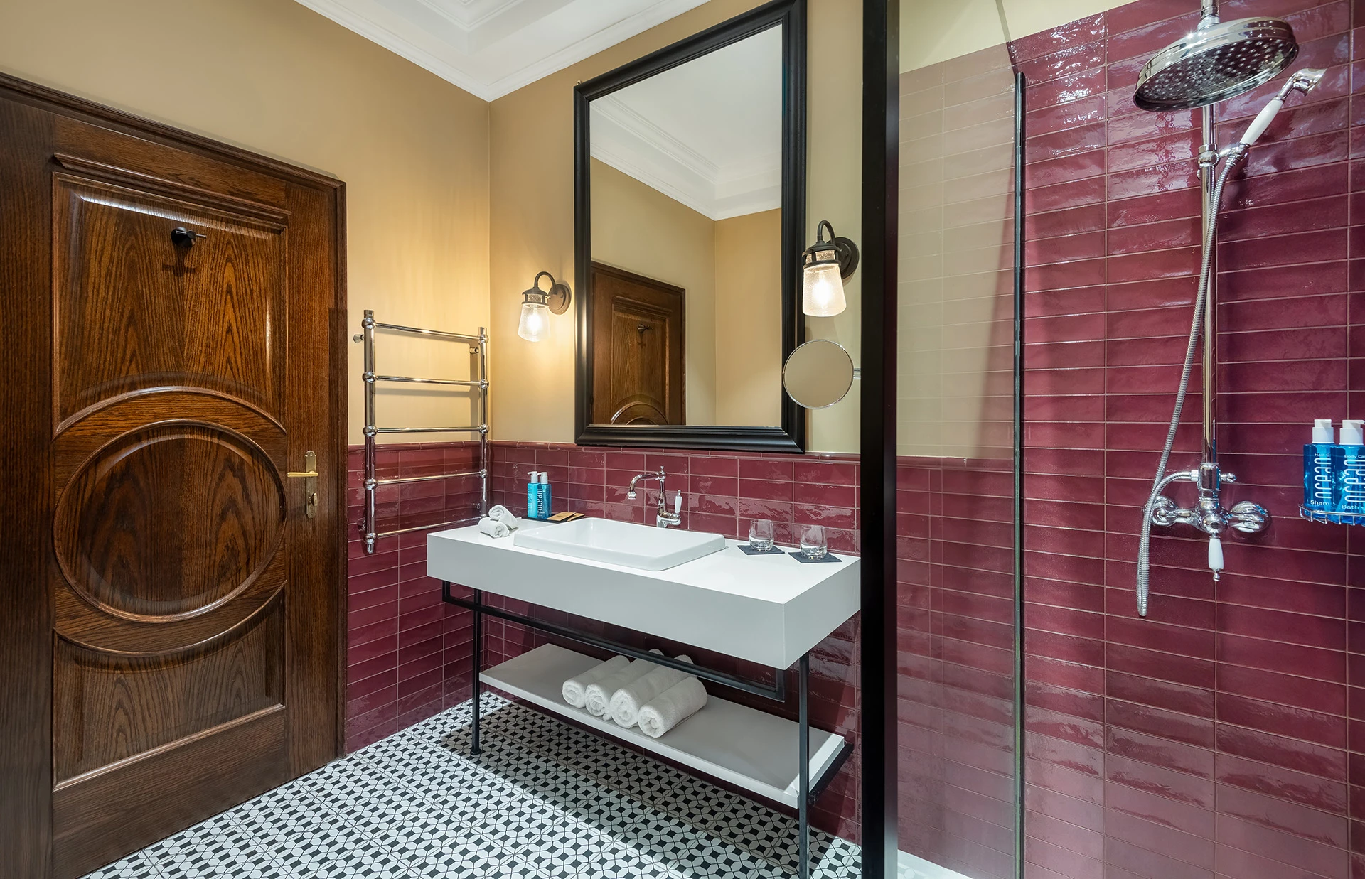 Modern hotel bathroom with red tiles and walk-in shower