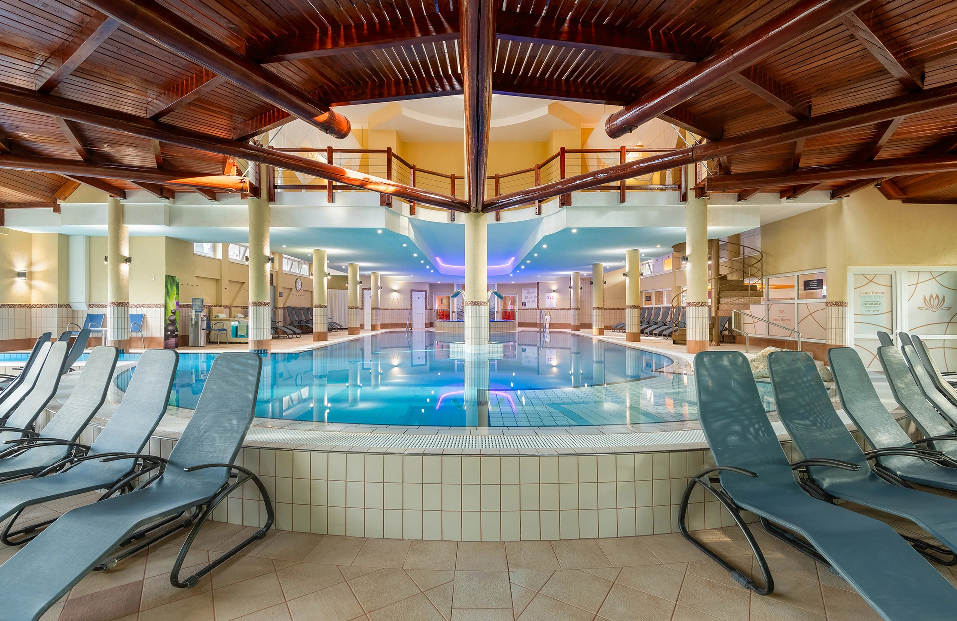 Interior view of a spa with turquoise pool and lounge chairs