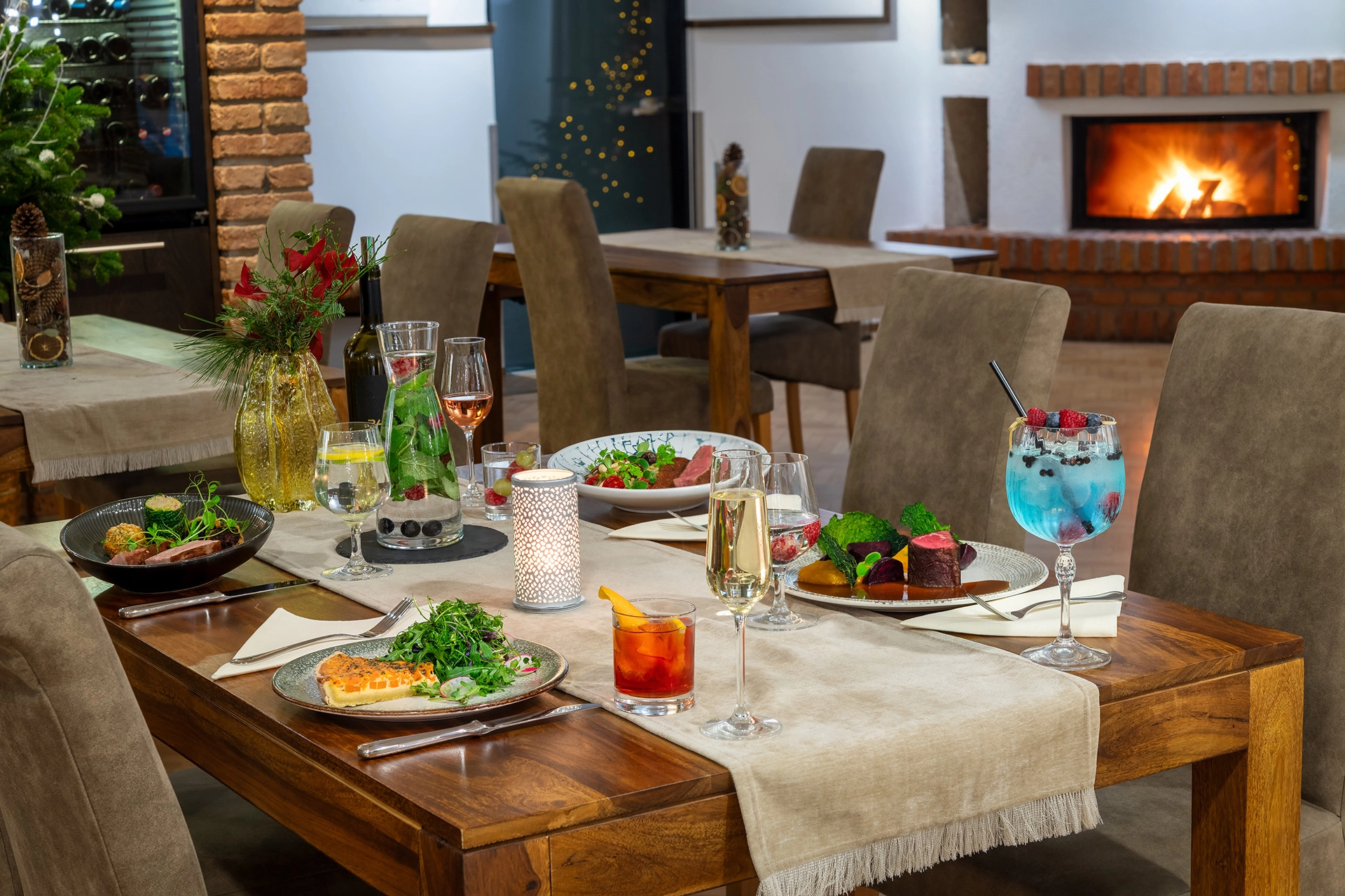 Elegant dining table setup with plated food, cocktails, and wine in restaurant