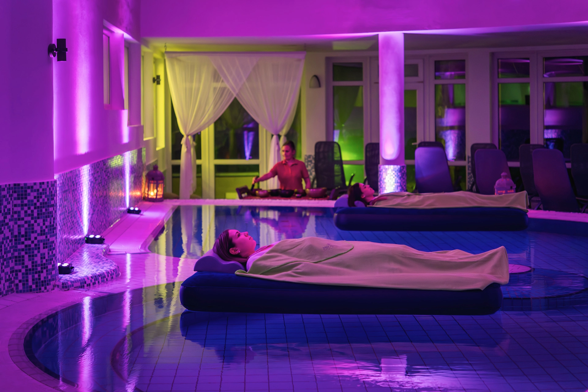 Guests floating on water during sound bowl therapy in spa