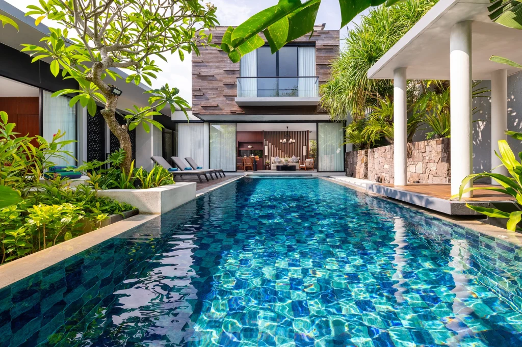 Luxury tropical villa pool in Bali surrounded by lush greenery and modern architecture